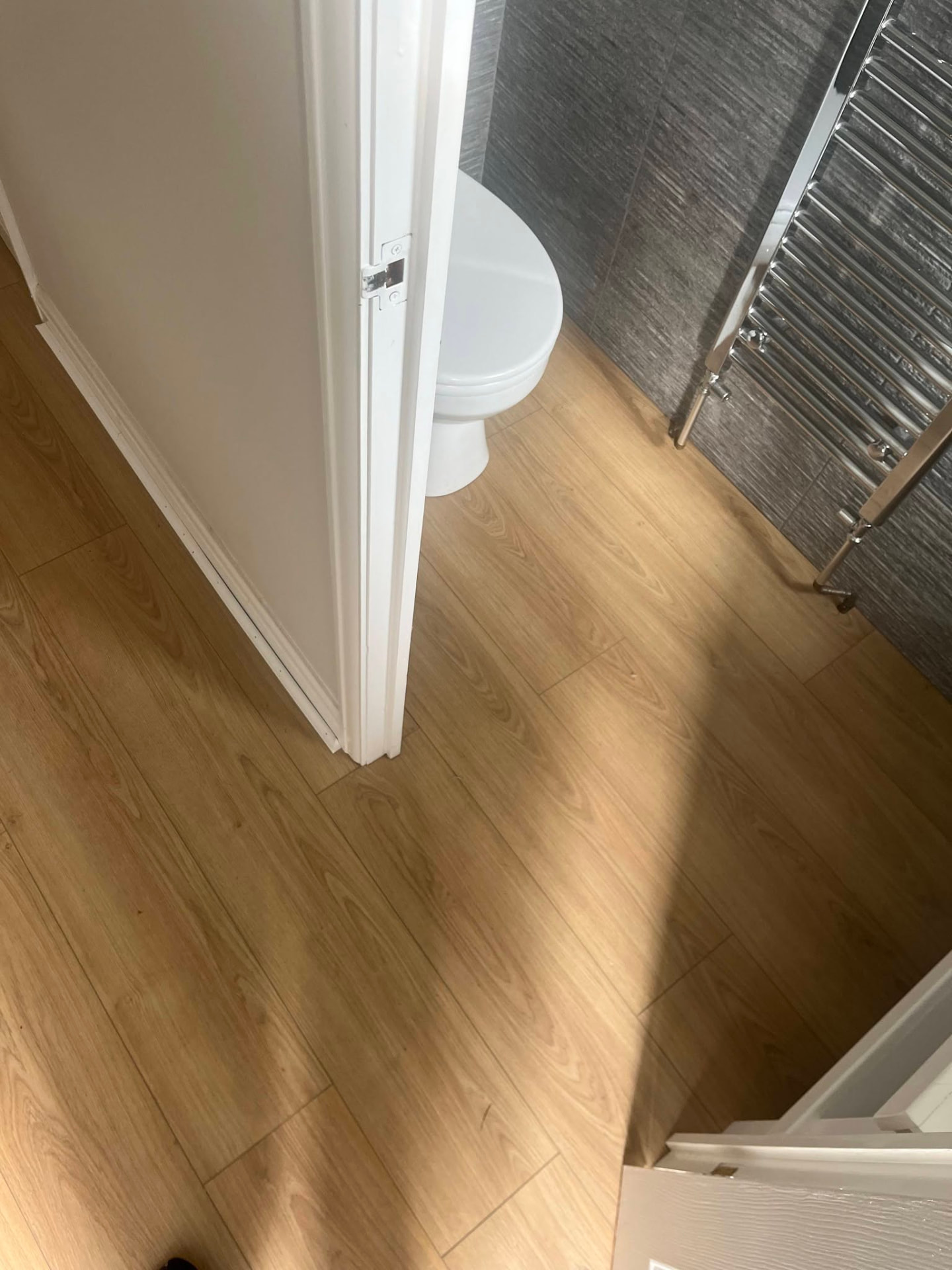 Warm laminate flooring continuing neatly through a doorway