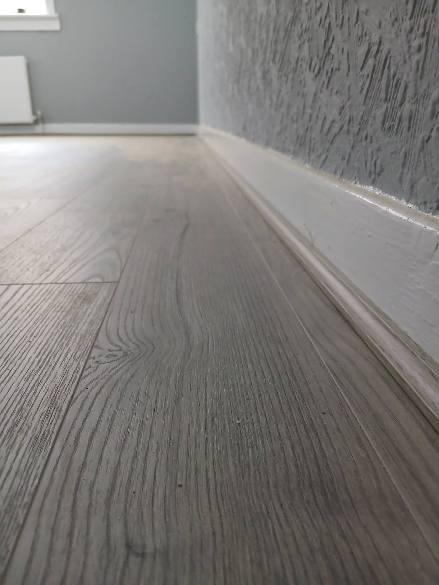 Close-up showing clean laminate grain and skirting detail